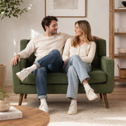 Loveseat sofa in a bright room styled with a floor lamp and side table