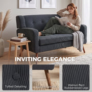 Woman reading on the dark grey loveseat with tufted detailing and walnut-effect leg insets