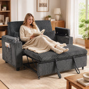 Woman relaxing on the dark grey sofa bed with a throw blanket and cup holder in use