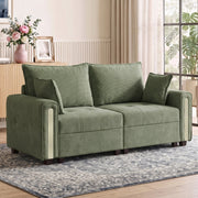 Small velvet couch styled in a living room with a vintage-style rug