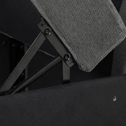Underside of a lifted seat showing the metal spring hinge