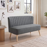 Dark grey 2 seater sofa in a bright living room beside a round side table