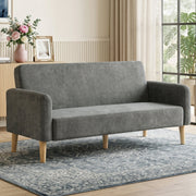 Grey velvet sofa styled in a living room beside a sideboard and curtains
