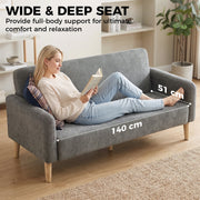 Woman reading with feet up on the wide 140cm seat of the grey sofa