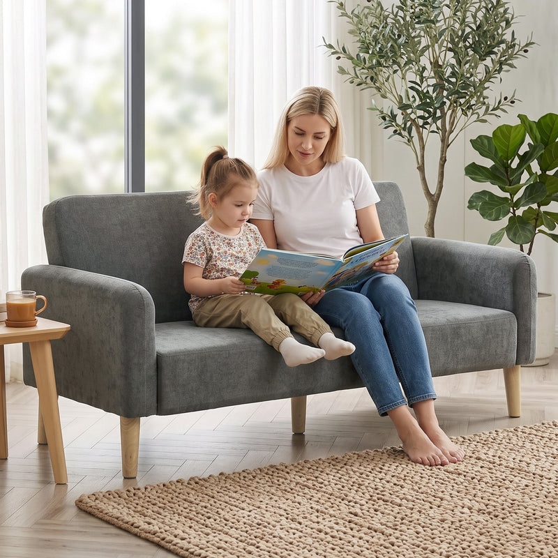 Mother and child sitting together on the grey velvet 2 seater sofa