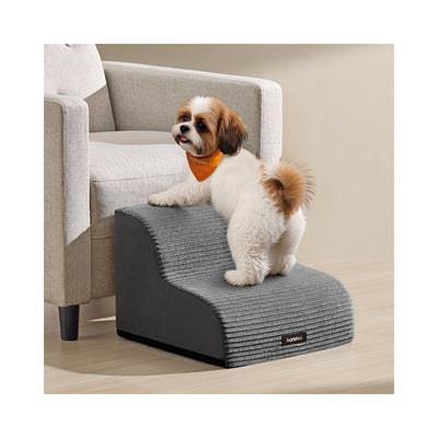 Small dog climbing the Feandrea 2-step dog stairs beside an armchair