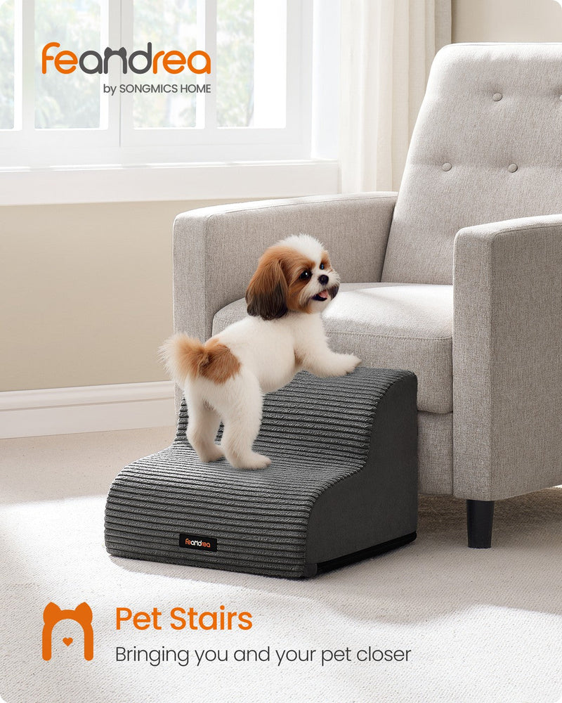 Lifestyle photo of a small dog using the stairs beside a sofa in a living room