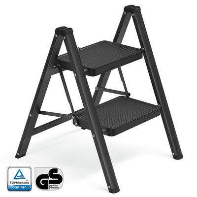 Black 2-step folding ladder standing open, with TUV Rheinland and GS safety marks