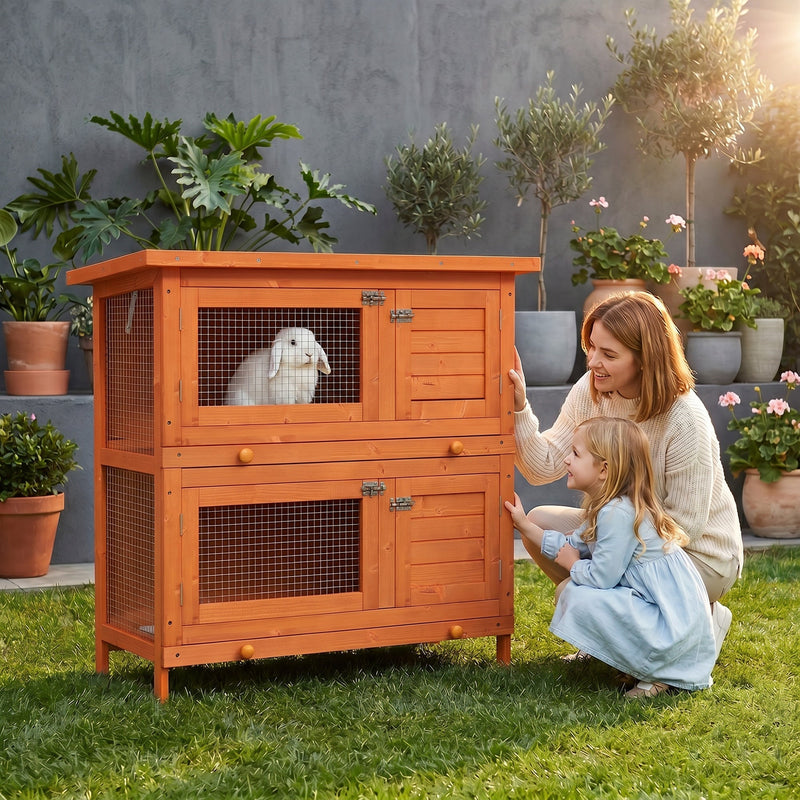 Lifestyle photo of a family with a rabbit inside the hutch outdoors on grass