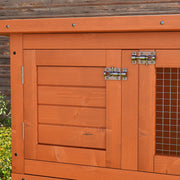 Close-up of a wooden door latch and wire mesh panel