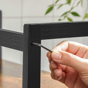 Close-up of the black frame being put together with a small assembly tool
