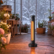 Black patio heater standing in a snowy conservatory among flowers