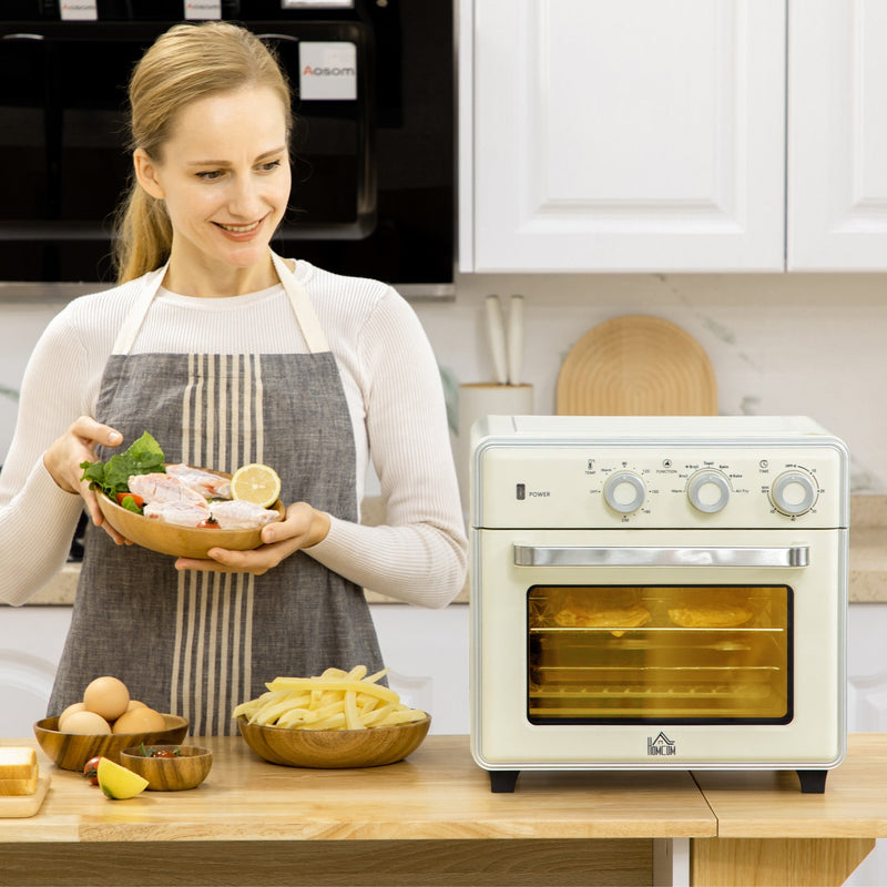Woman in a kitchen holding fresh ingredients beside the cream Homcom oven