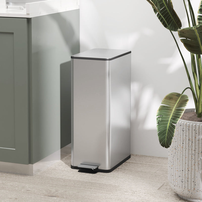 Silver 20L slim stainless steel pedal bin beside a green cabinet and houseplant