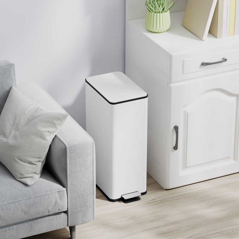 White 20L slim stainless steel pedal bin closed beside a sofa and white cabinet