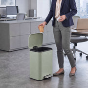 Woman in an office dropping a cup into an open 20L pedal bin