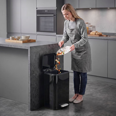 Woman scraping food into an open 20L pedal bin in a modern kitchen