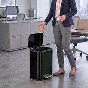 Woman in an office dropping a cup into an open 20L pedal bin