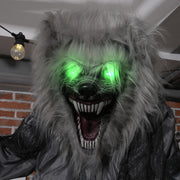 Skeleton werewolf decoration displayed outside a wooden barn at night