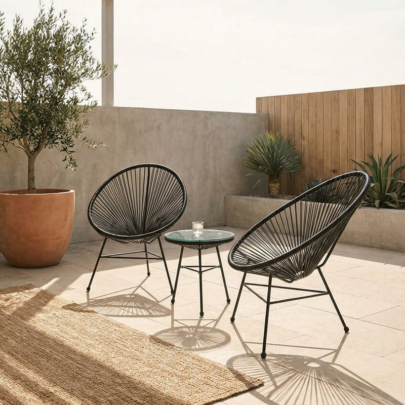 Black rattan 3 piece bistro set in an outdoor garden setting