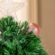 Close-up of the clear star topper and a bauble on green branch tips