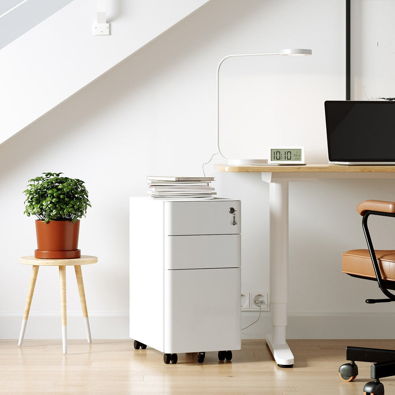 White filing cabinet beside a home office desk with a laptop and plant