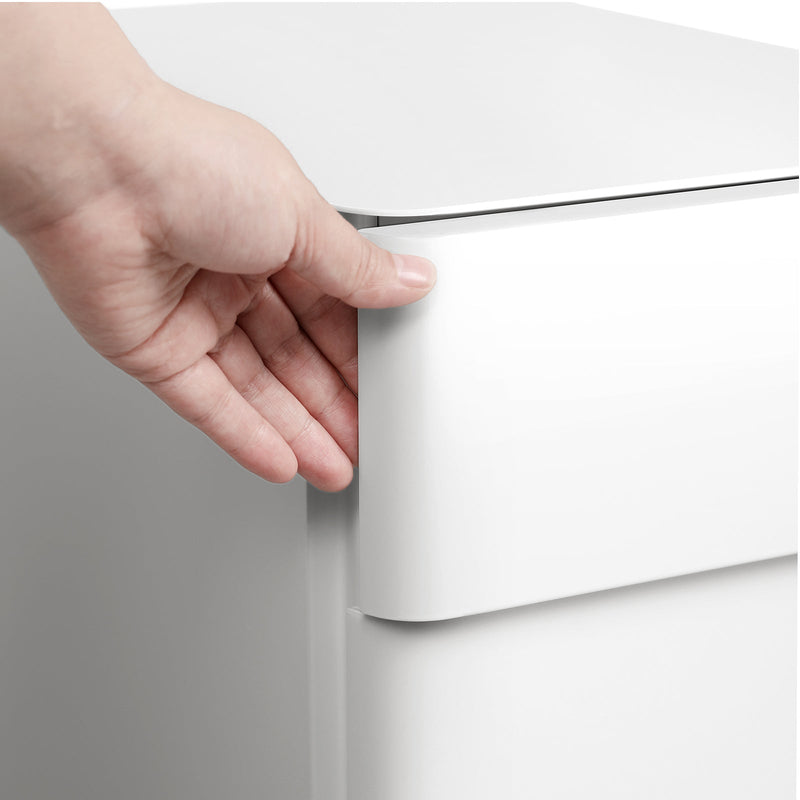 Hand opening the white filing cabinet using its recessed top drawer edge