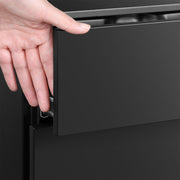 Close-up of a hand opening a drawer using the recessed edge pull