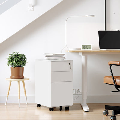 White file cabinet beside a height adjustable desk in a home office, next to a plant on a stool