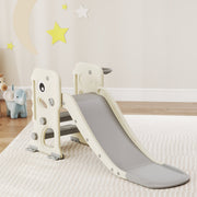 Aiyaplay kids slide in cream white and grey set up on a rug beside soft toys