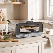Mini oven on a kitchen worktop in oven mode roasting chicken and vegetables