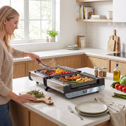 Woman turning food on the appliance opened out flat as a BBQ griddle
