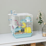 Blue 3-level hamster cage styled on a white shelf with dried flowers