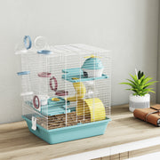 Blue hamster cage displayed on a wooden table with a potted plant