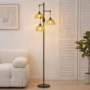 Lit 3-light floor lamp beside a white armchair and shuttered doors