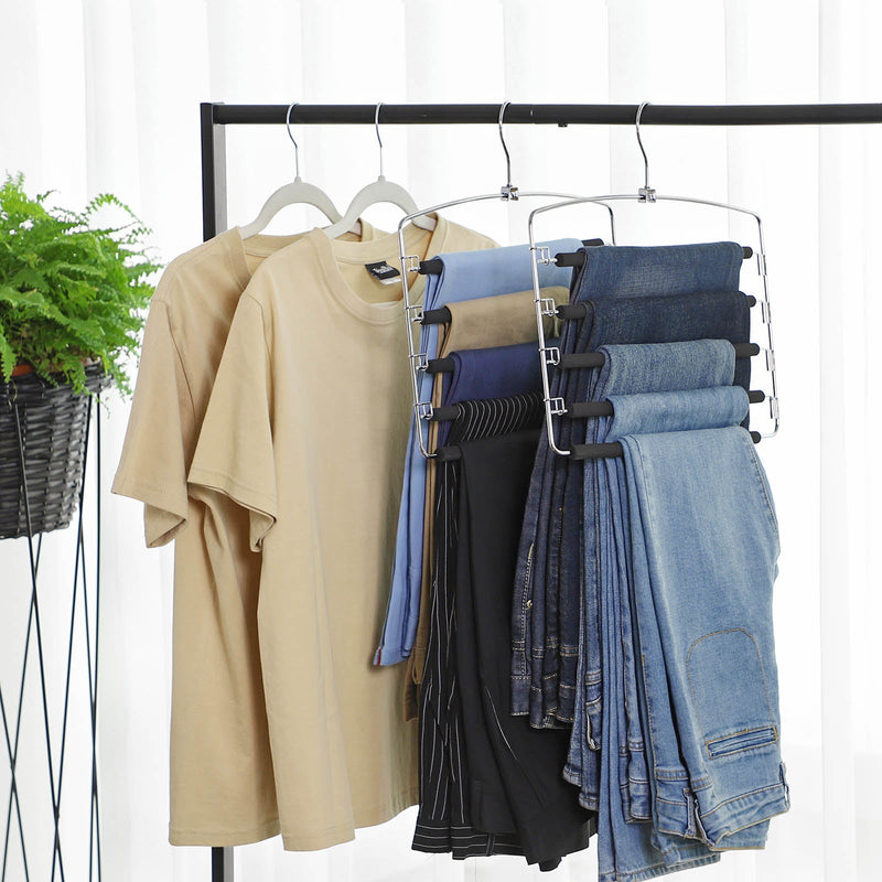Trouser hangers holding folded jeans beside shirts on a black clothes rail