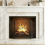 Fireplace screen standing in front of a lit fire in a white marble surround