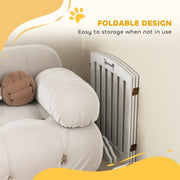 Dog gate folded flat and tucked beside a sofa, showing the foldable storage design