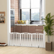 White dog gate fitted across a kitchen doorway beside a potted plant
