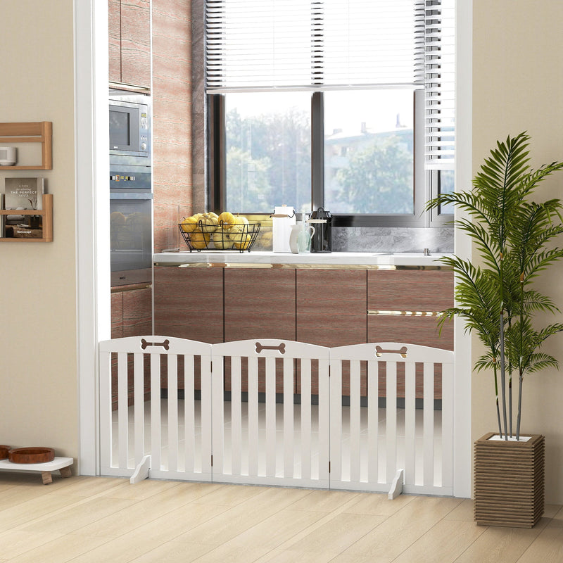 White dog gate fitted across a kitchen doorway beside a potted plant