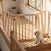 Small dog sitting on a landing behind the pine gate fitted across a staircase