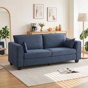 Dark blue 3 seater sofa in a bright living room with a rug and floor lamp