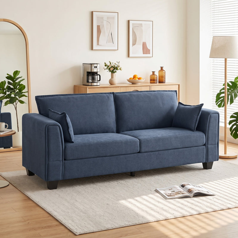 Dark blue 3 seater sofa in a bright living room with a rug and floor lamp