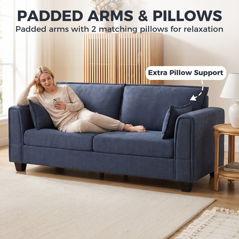 Woman lying on the dark blue sofa with padded arms and 2 matching pillows