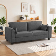 Dark grey 3 seater sofa in a bright living room with a rug and floor lamp