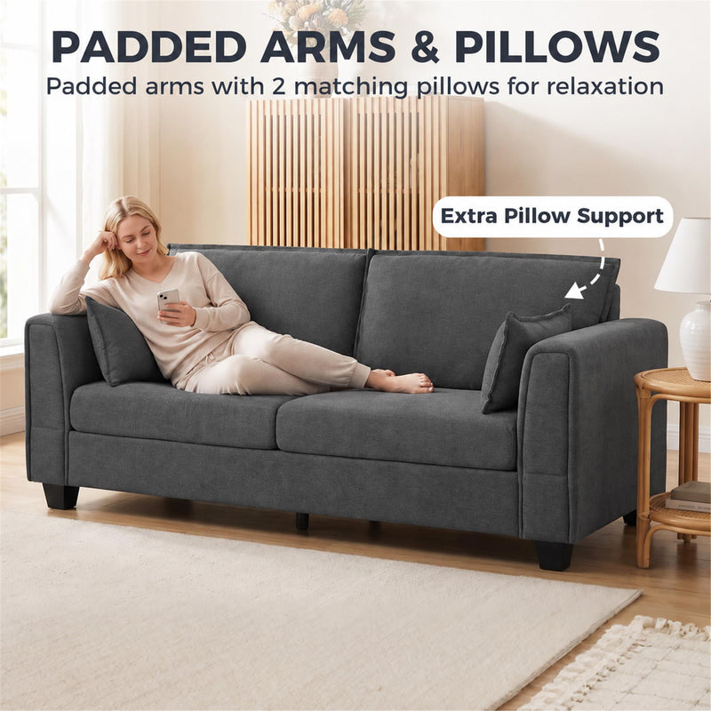 Woman lying on the dark grey sofa with padded arms and 2 matching pillows