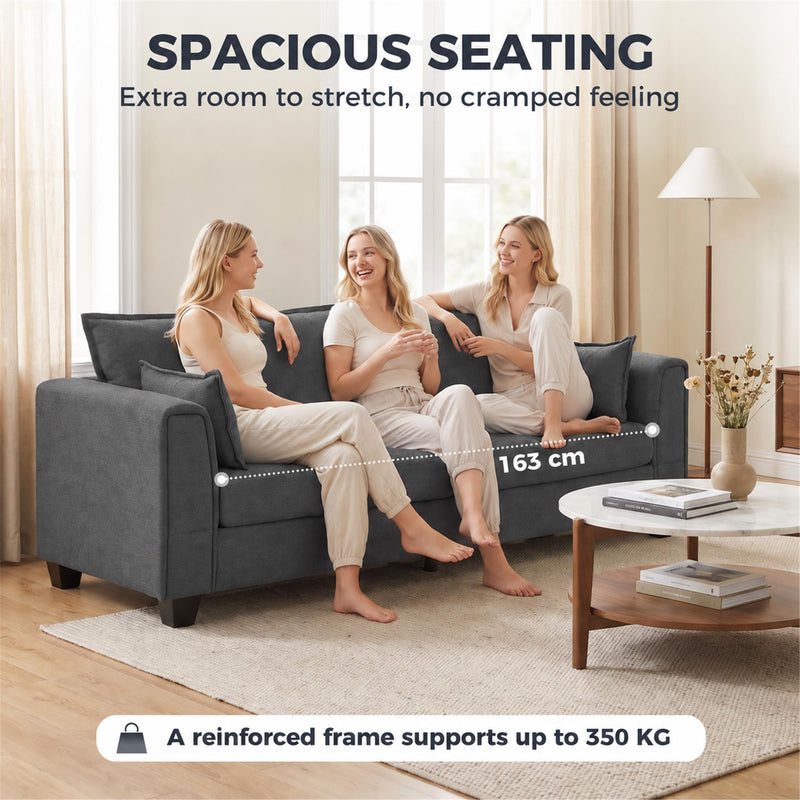 Three people sitting on the dark grey sofa with a 163 cm seat width marked