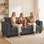 Three friends chatting on the dark grey 3 seater sofa in a bright living room