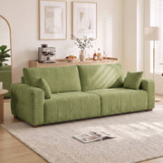 Green 3 seater sofa in a bright living room beside a floor lamp and rug