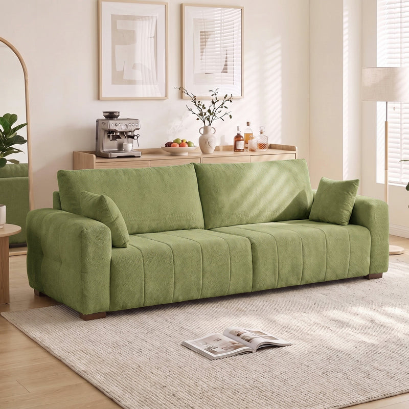 Green 3 seater sofa in a bright living room beside a floor lamp and rug